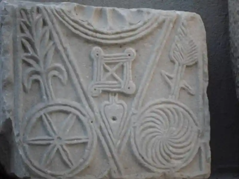 Six-pointed disc, swirls, solar discs, leaves, cross engraved on a marble stone, located at the Archaeological Museum of Izmir, Turkey